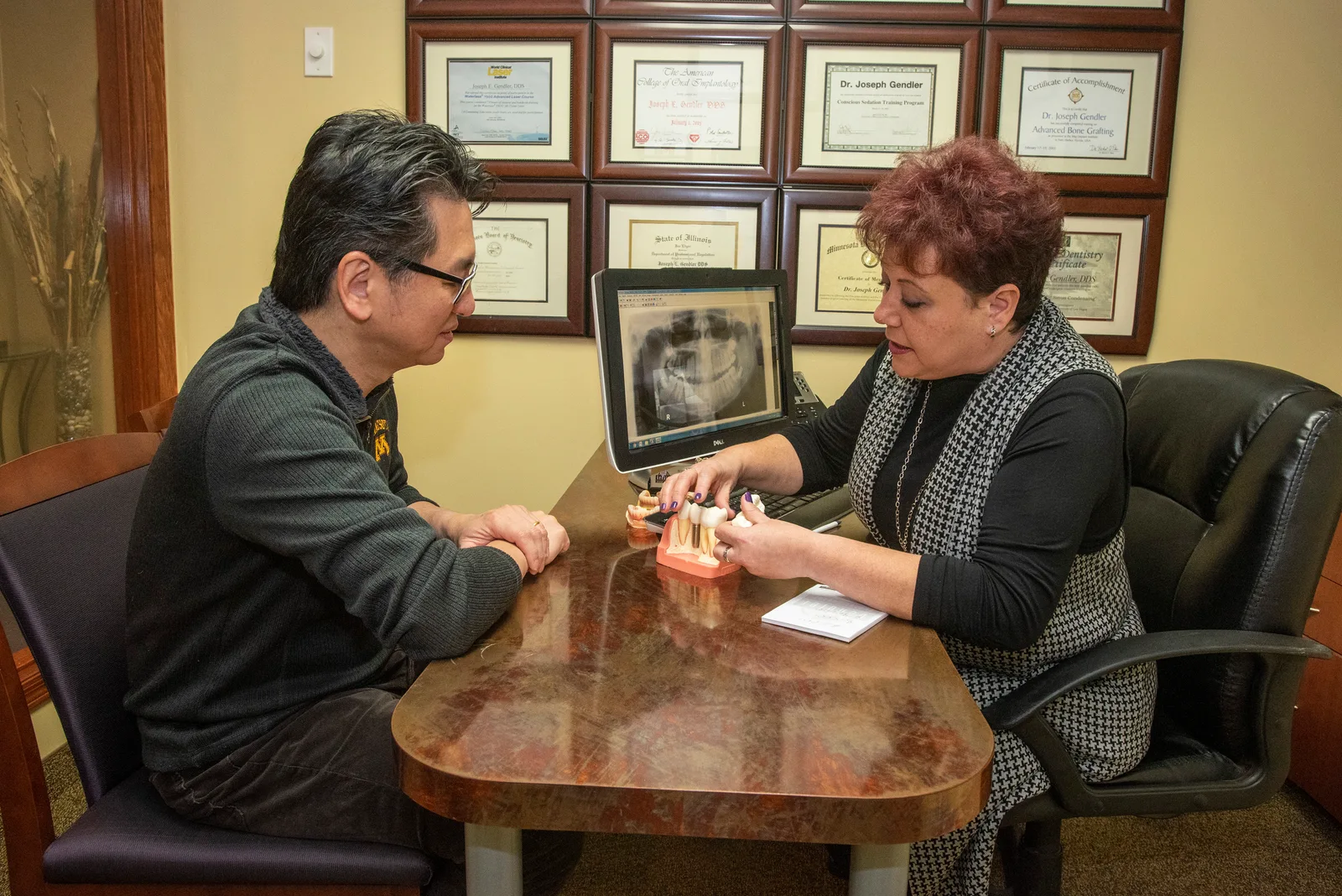 A Gendler Dental Center team member reviewing dental implant treatment options with a patient